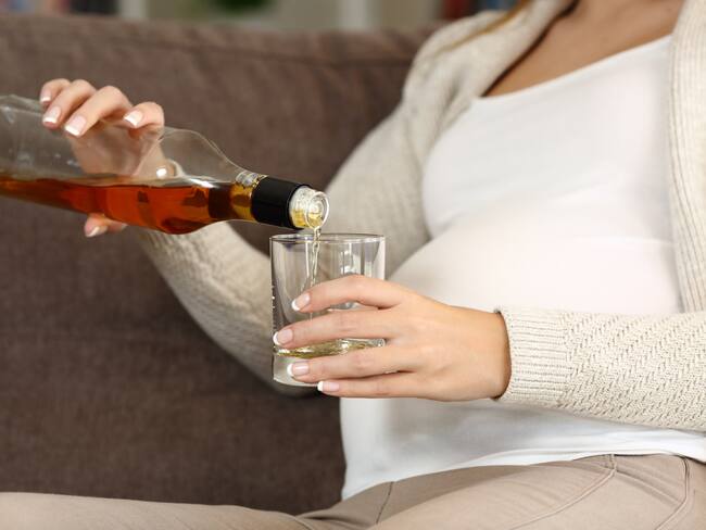 Mujer embarazada tomando una bebida alcohólica