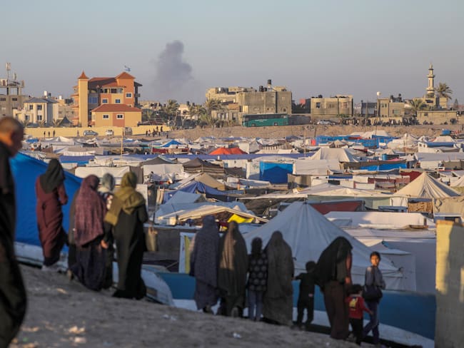 -FOTODELDIA- Rafah (-), 07/05/2024.- Desplazados internos palestinos permanecen en un campamento mientras se eleva humo al fondo tras un ataque aéreo israelí, en Rafah, sur de la Franja de Gaza, 07 de mayo de 2024 (publicado el 08 de mayo de 2024). El 6 de mayo, las Fuerzas de Defensa de Israel (FDI) pidieron a los residentes del este de Rafah que evacuaran &quot;temporalmente&quot; a una zona humanitaria ampliada. EFE/MOHAMMED SABER