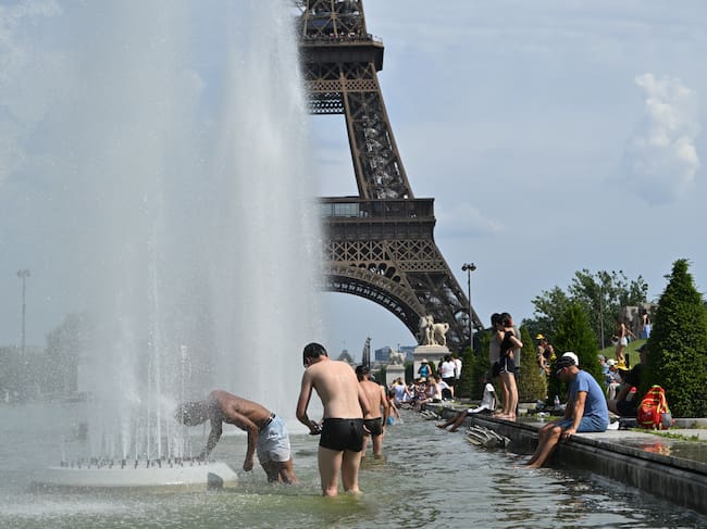 Personas bañándose en el fuentes cerca de la Torre Eiffel por ola de calor que atraviesa Francia: Getty Images.