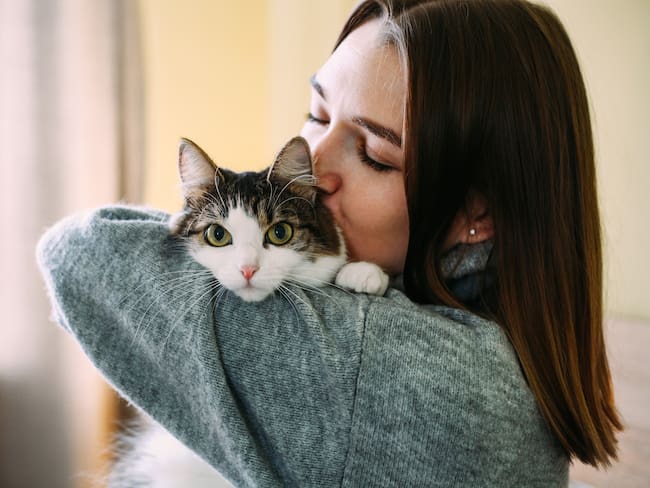 Mujer abrazando a su gato (Foto vía Getty Images).