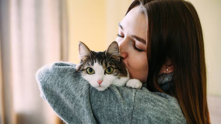 Mujer abrazando a su gato (Foto vía Getty Images).