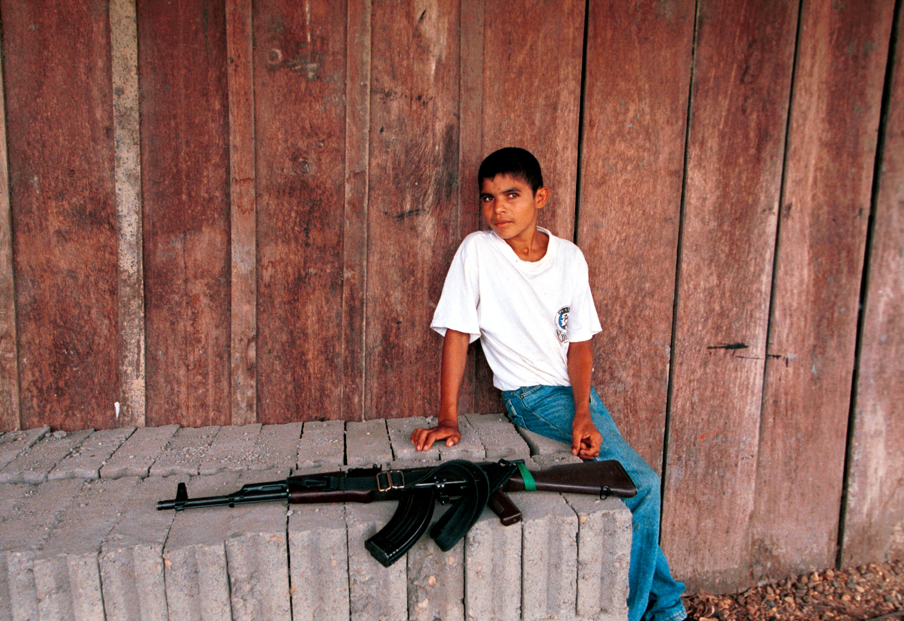 Niño junto a un AK-47 en un "punto de requisa" de las FARC en 2001 en Cristales (Colombia) 
(Foto:    Carlos Villalon/Newsmakers)