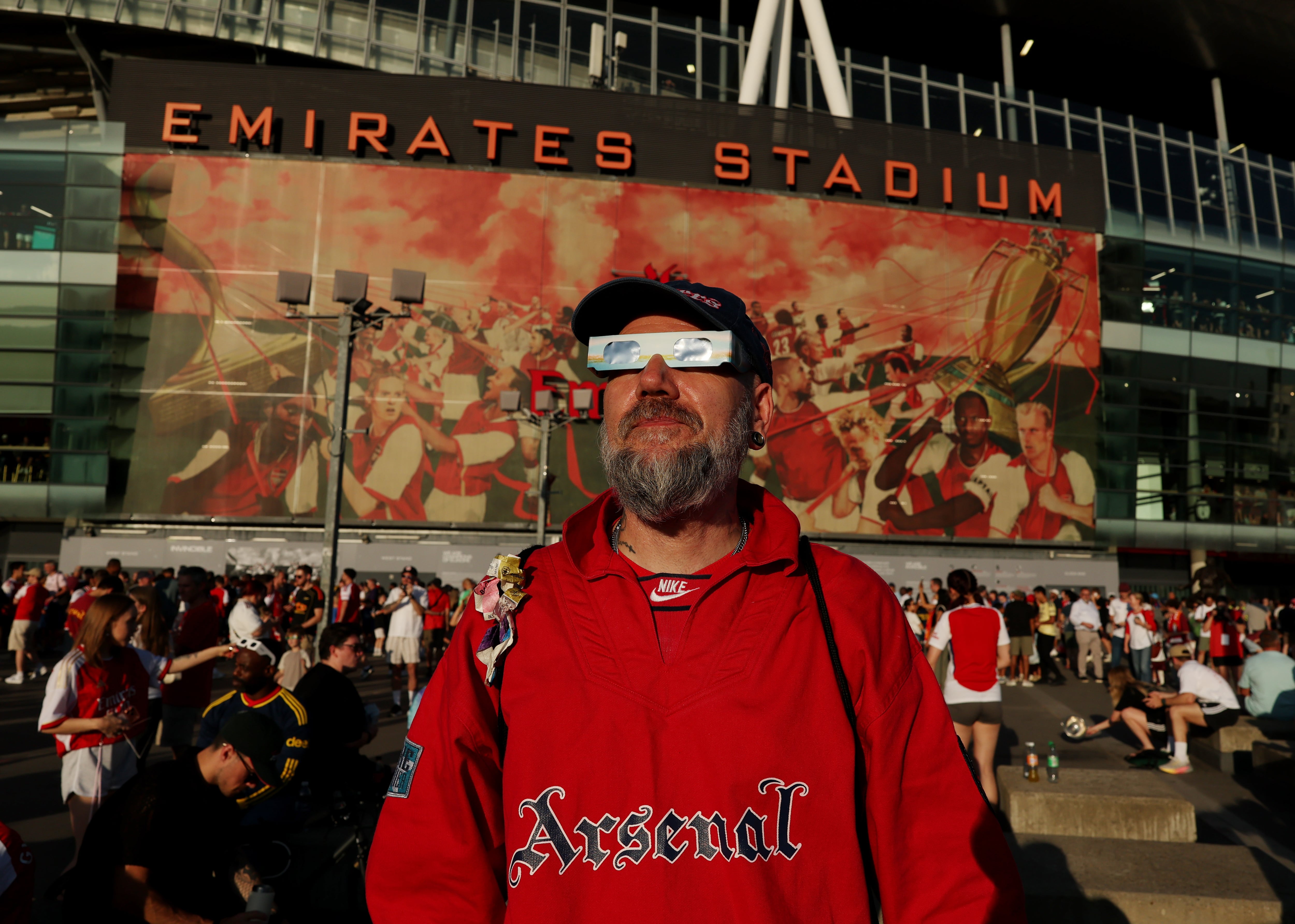 Hincha del Arsenal itilizando gafas para observar el eclipse durante el partido entre Arsenal FC y Como en Londres, Inglaterra. (Photo by Alex Pantling/Getty Images)