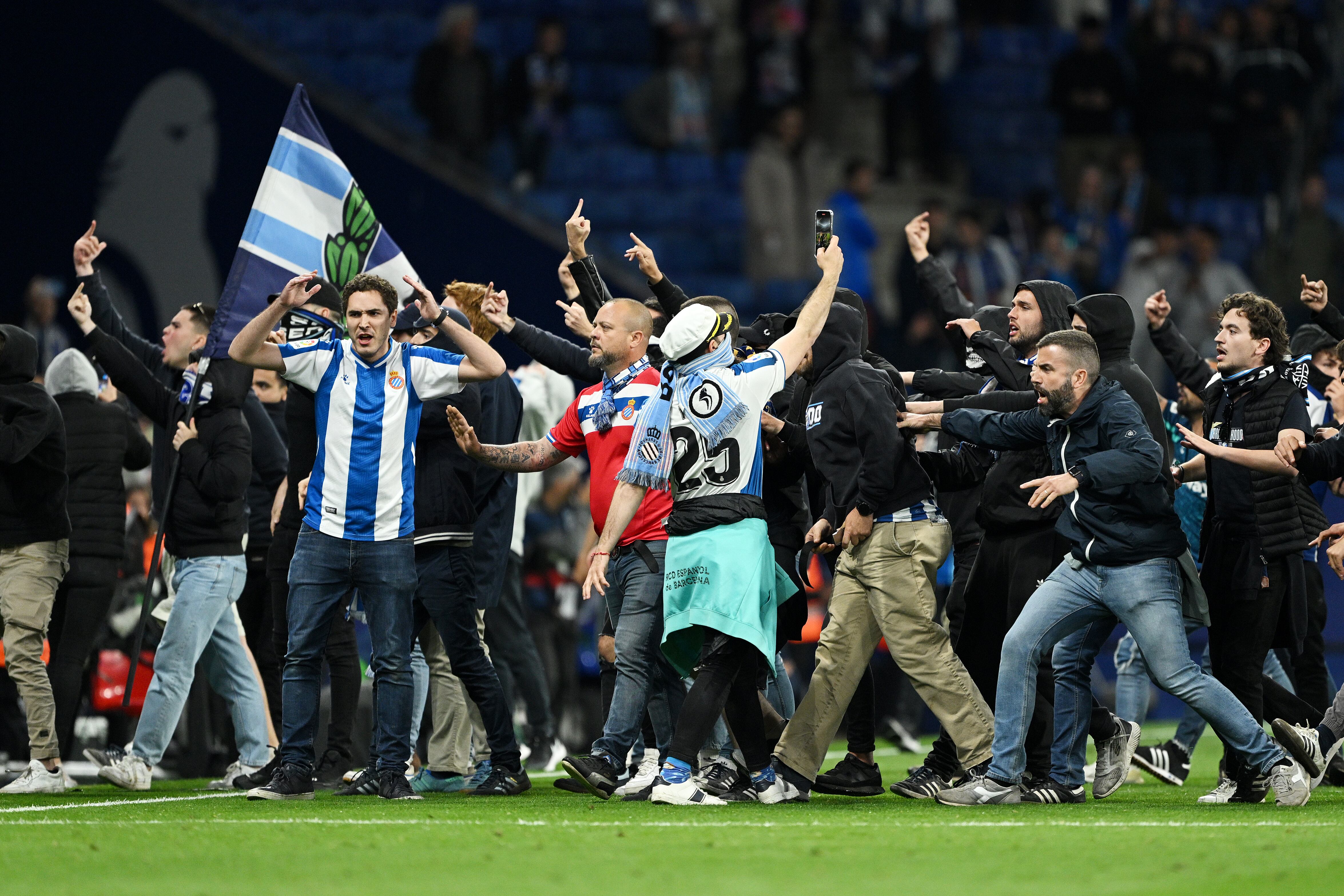 Hinchas del Espanyol invaden la cancha mientras los jugadores del Barcelona celebran el título de Liga. (Photo by David Ramos/Getty Images)