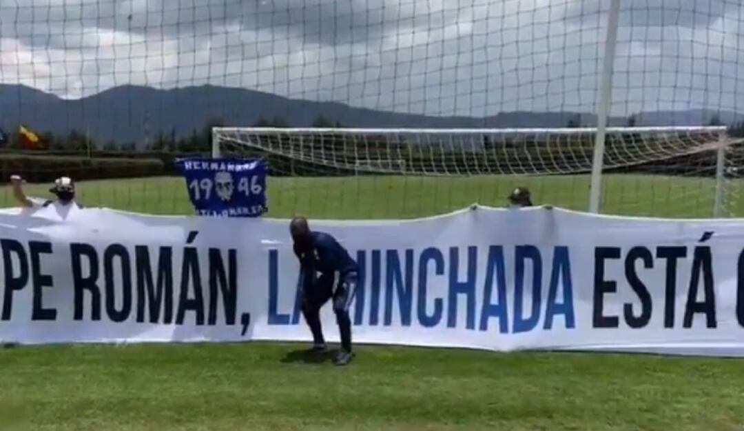 Felipe Román posa junto a una bandera que los hinchas hicieron en muestra de apoyo.