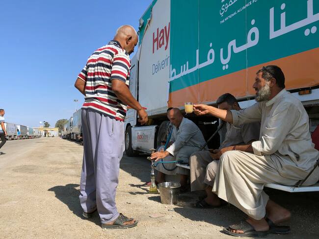 Rafah (Egypt), 17/10/2023.- People rest near a parked truck, which is part of a humanitarian aid convoy for the Gaza Strip, outside the Rafah border gate, Egypt, 17 October 2023. As international mediators continue to push for the passage of aid into Gaza and the exit of foreign nationals fleeing the conflict, from it, Egypt's border crossing with the Gaza Strip in Rafah remained closed on 16 October, with the international aid convoys mostly stationed in the town of Arish some 50km away from Rafah. (Egipto) EFE/EPA/STRINGER