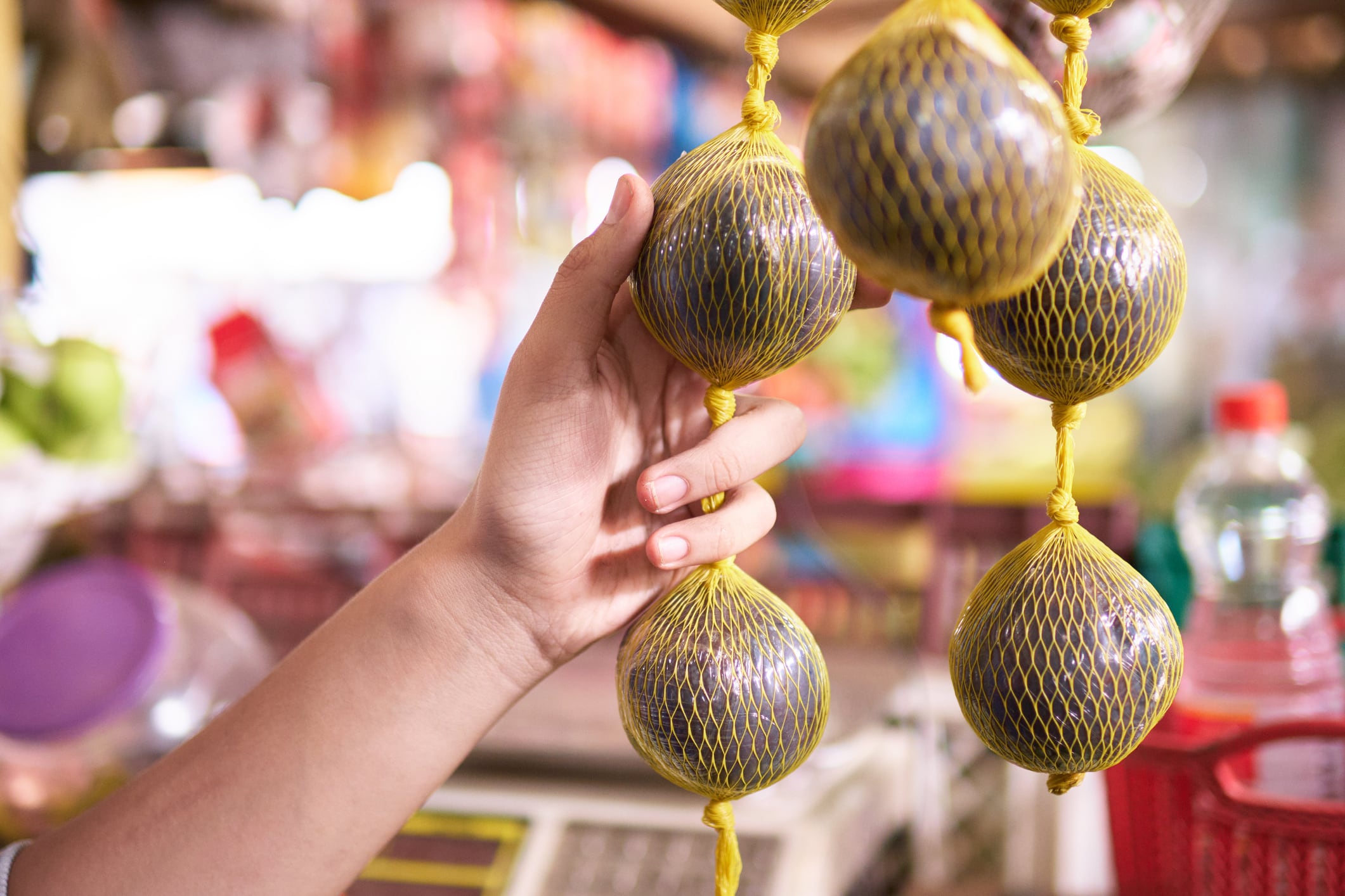 Persona eligiendo el borojó en la plaza de mercado (Getty Images)