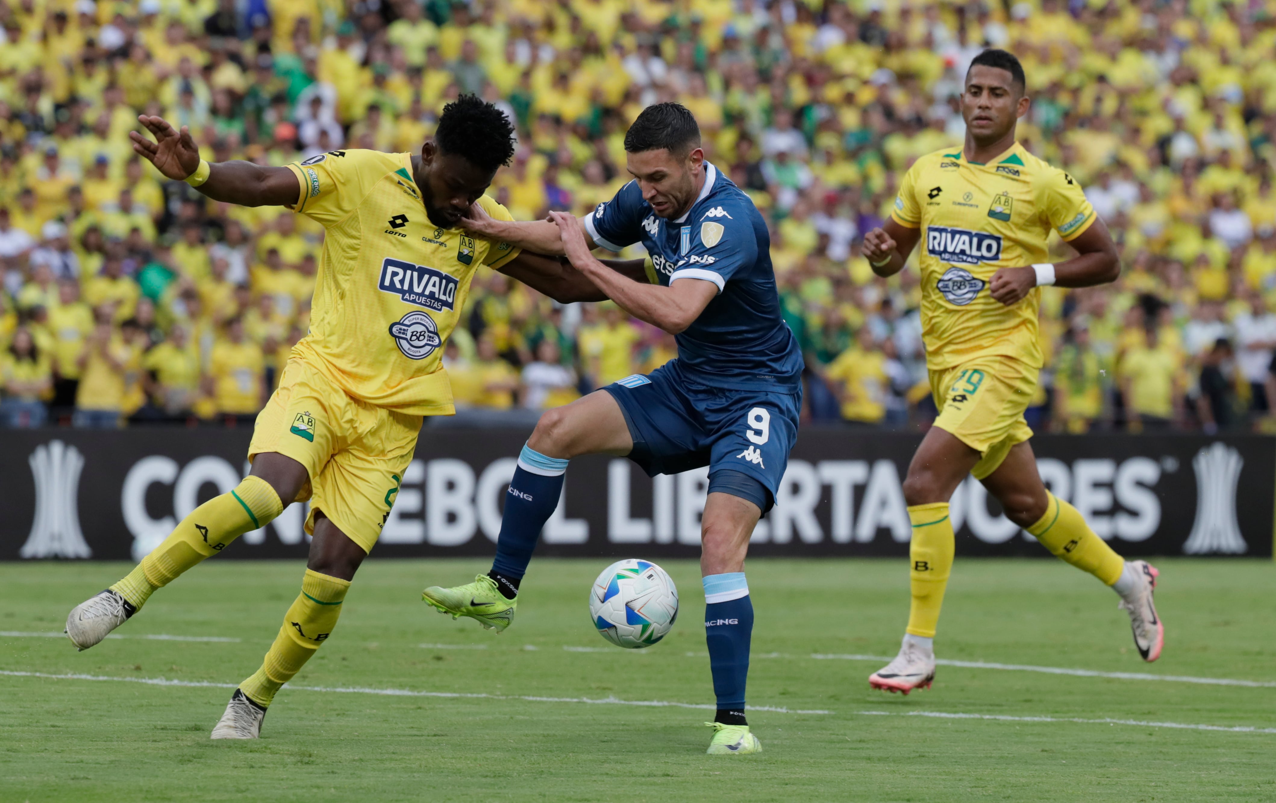 AMDEP5875. BUCARAMANGA (COLOMBIA), 06/05/2025.- Carlos Romaña (i) de Bucaramanga disputa el balón con Adrián Emmanuel Martínez (c) de Racing este martes, en un partido de la fase de grupos de la Copa Libertadores entre Atlético Bucaramanga y Racing en el estadio Américo Montanini en Bucaramanga (Colombia). EFE/ Carlos Ortega
