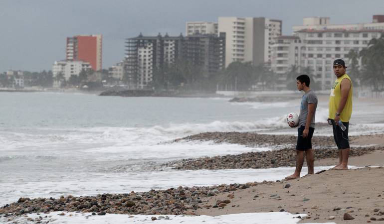 Unas personas caminan por la playa de Puerto Vallarta (México), que permanece en calma tras el paso del huracán Patricia.
