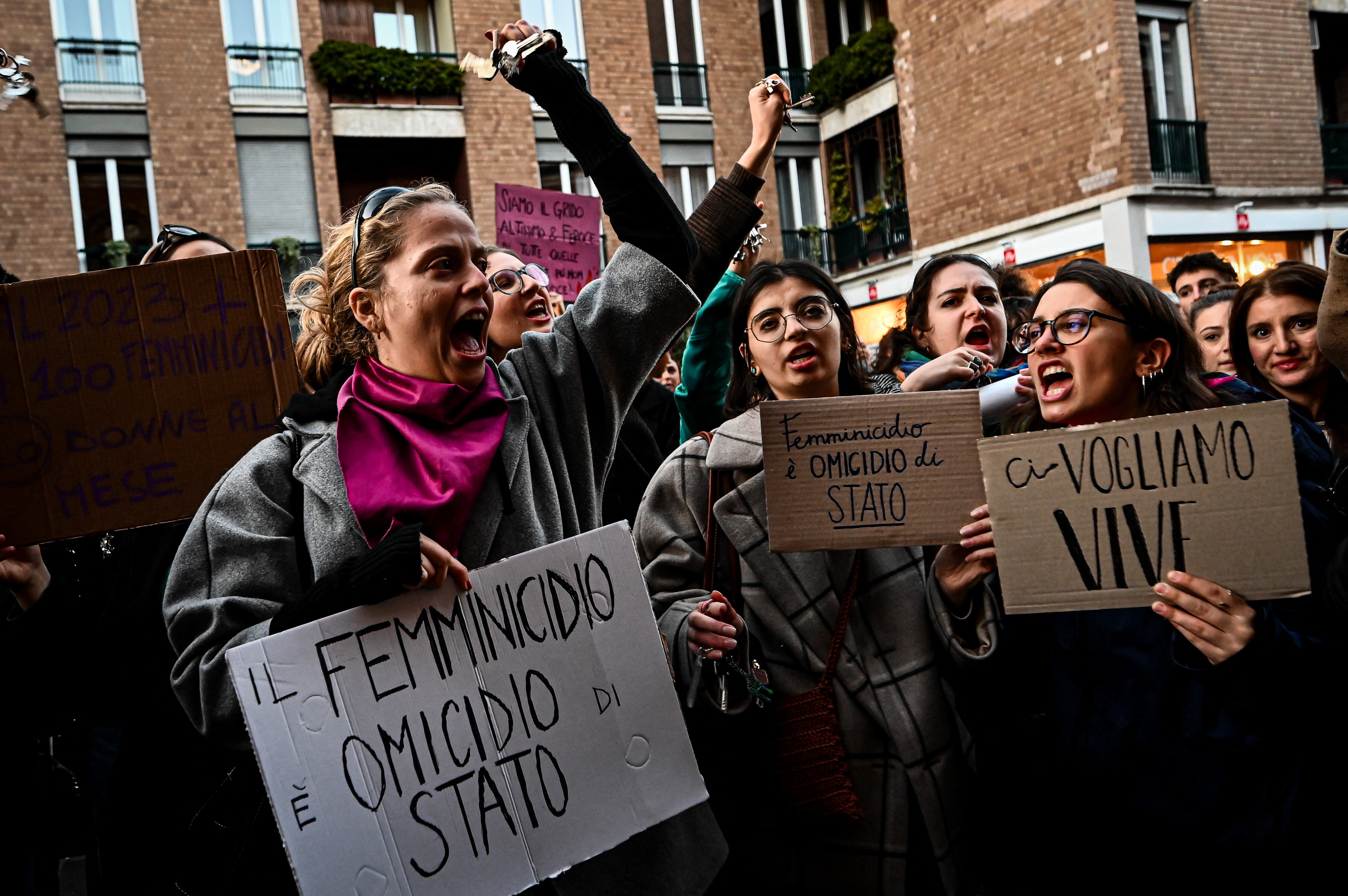 Protesters hold placards reading 'Femicide is a state homicide' and 'We want us alive' outside the University of Milan during a demonstration following the suspected feminicide of 22-year-old Giulia Cecchettin, in Milan, on November 22, 2023. A court in Germany said on November 22 it has approved the extradition of a 22-year-old Italian university student arrested in Germany for allegedly kidnapping and killing his former girlfriend. The suspect's lawyer had identified him as Filippo Turetta, who went missing more than a week ago along with his fellow student and former girlfriend Giulia Cecchettin. In the year to November 12, there have been 102 murder cases with female victims in Italy, 82 of whom were killed by family members or current or former partners, according to the interior ministry. (Photo by Piero CRUCIATTI / AFP)