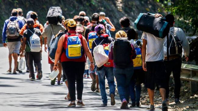 Migrantes venezolanos caminando por una vía en Cúcuta