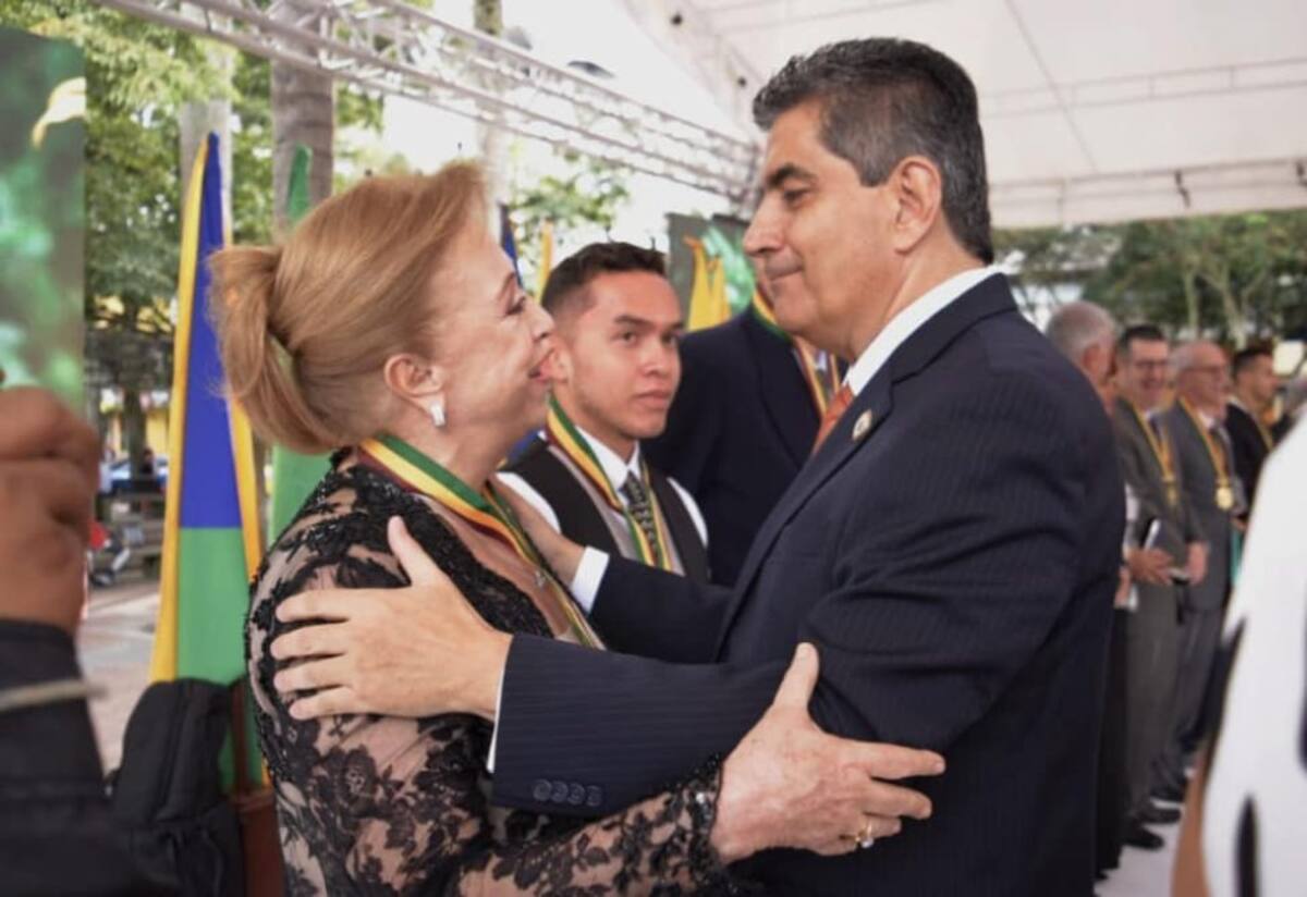 Gobernador entregando reconocimiento a Clara Luz Jaramillo de Botero por sus servicios sociales de ayuda a la población menos favorecida del departamento.