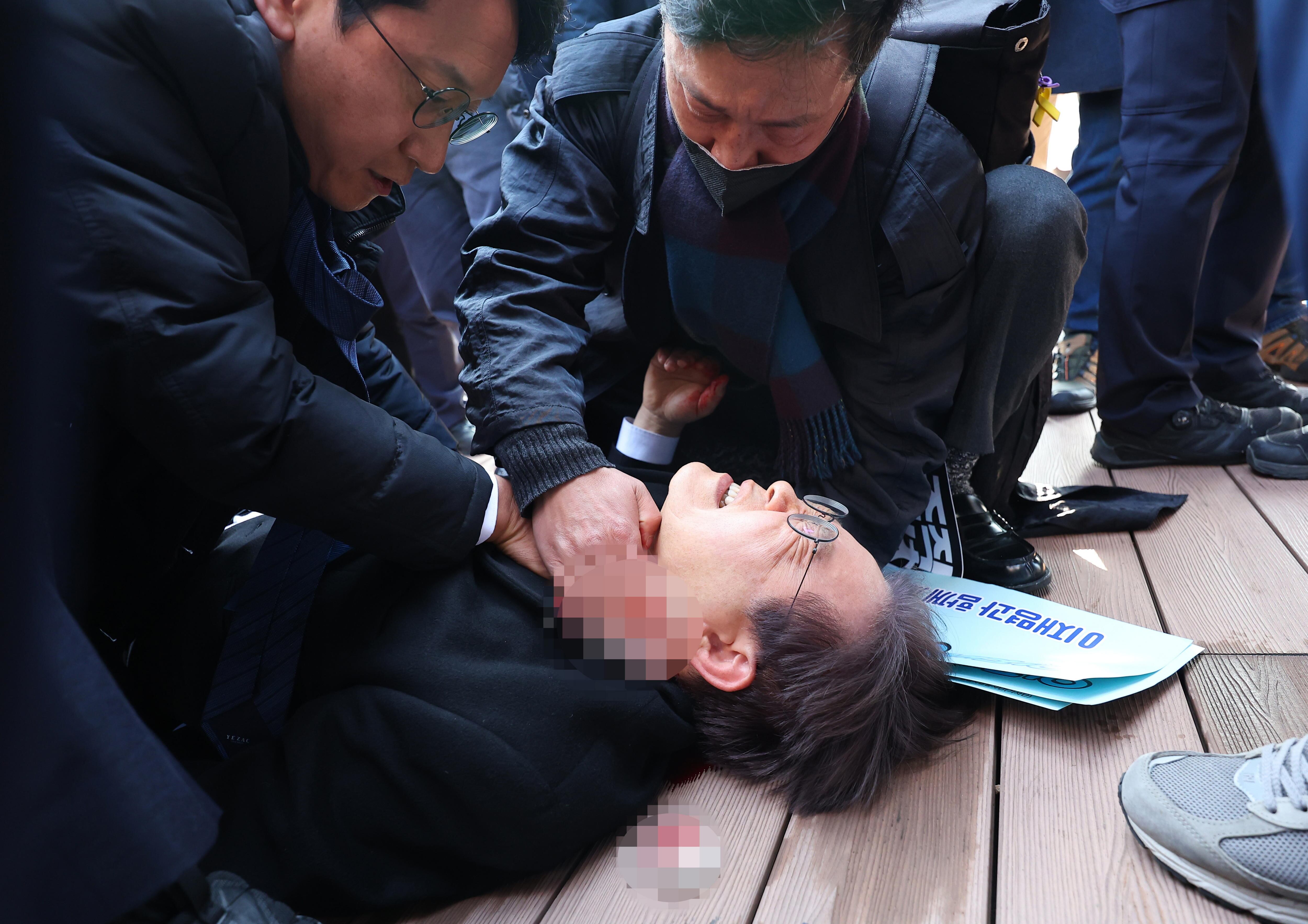 Busan (Korea, Republic Of), 02/01/2024.- Lee Jae-myung, leader of the main opposition Democratic Party, lies down after he was stabbed by an assailant on the left side of his neck during a visit to the construction site of an airport on Gadeok Island off the southeastern port city of Busan, South Korea, 02 January 2024. (Corea del Sur) EFE/EPA/YONHAP SOUTH KOREA OUTIMAGE PIXELLATED AT SOURCE
