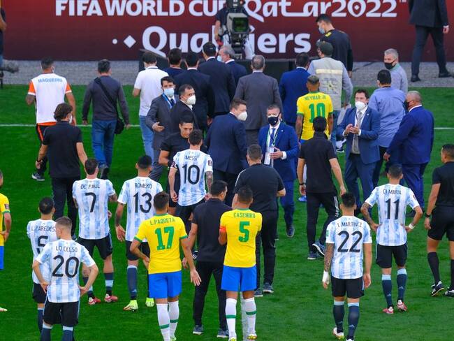 Los jugadores de Argentina y Brasil abandonan el campo de juego tras la intervención de las autoridades sanitarias.