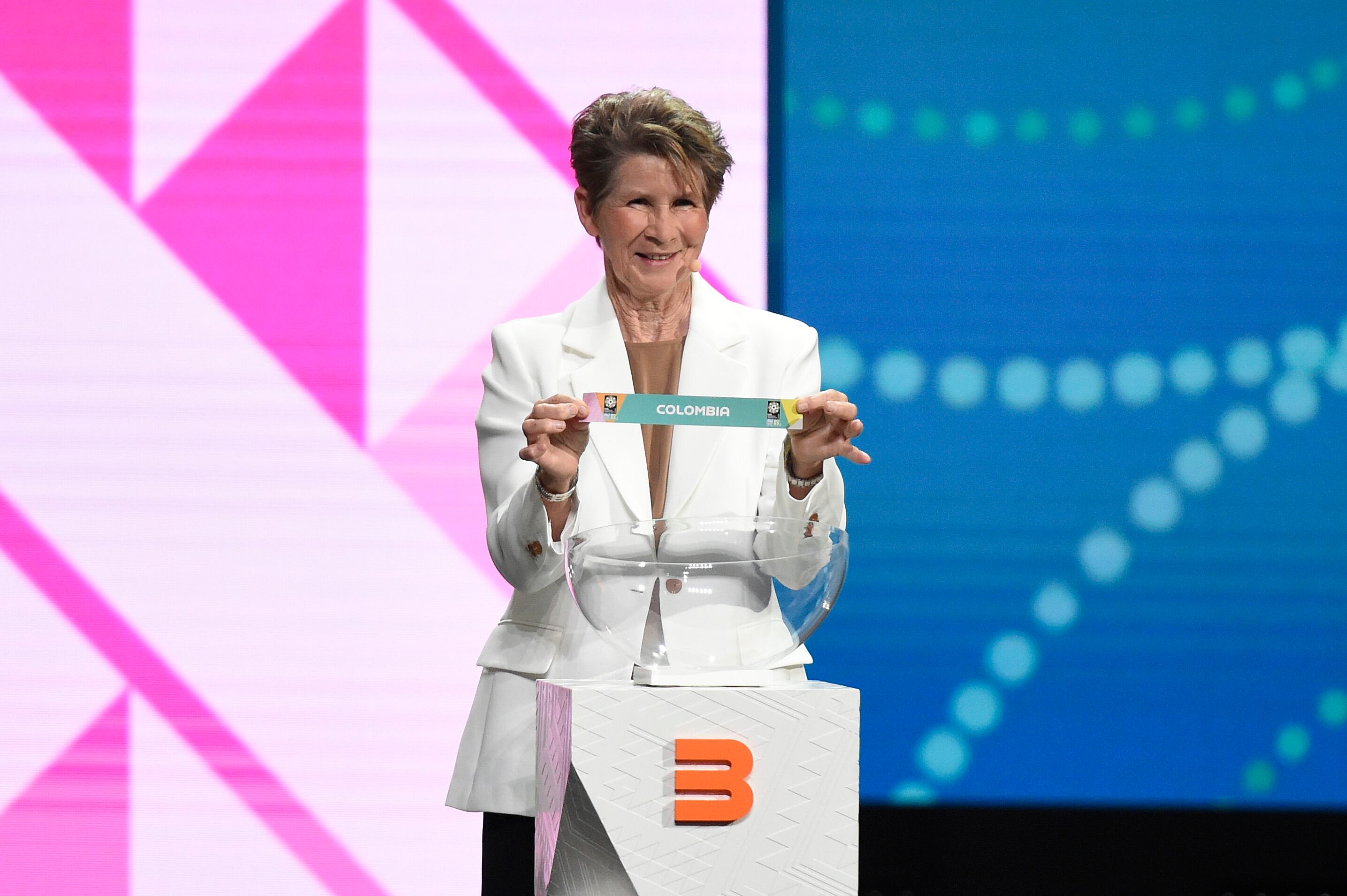 AUCKLAND, NEW ZEALAND - OCTOBER 22: Julie Dolan holds up the card for Colombia during the FIFA Women's World Cup 2023 Final Tournament Draw at Aotea Centre on October 22, 2022 in Auckland, New Zealand. (Photo by Matt Roberts - FIFA/FIFA via Getty Images)