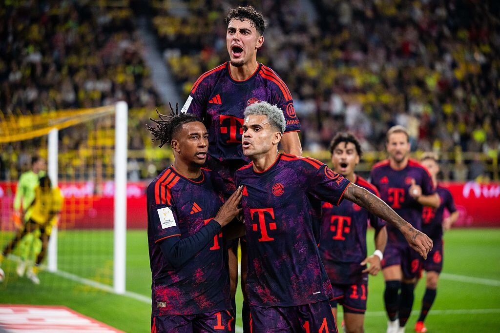 DORTMUND, GERMANY - AUGUST 22: Michael Olise (L) of FC Bayern Muenchen celebrates after scoring his team's second goal with Aleksandar Pavlovic and Luis Diaz (L-R) of FC Bayern Muenchen during the Franz Beckenbauer Supercup match between Borussia Dortmund and FC Bayern München at Signal Iduna Park on August 22, 2026 in Dortmund, Germany.  (Photo by Marvin Ibo Guengoer - GES Sportfoto/Getty Images)