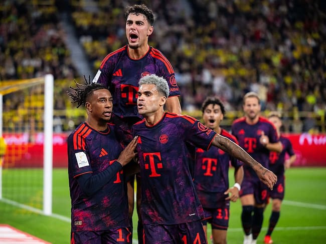 DORTMUND, GERMANY - AUGUST 22: Michael Olise (L) of FC Bayern Muenchen celebrates after scoring his team's second goal with Aleksandar Pavlovic and Luis Diaz (L-R) of FC Bayern Muenchen during the Franz Beckenbauer Supercup match between Borussia Dortmund and FC Bayern München at Signal Iduna Park on August 22, 2026 in Dortmund, Germany. (Photo by Marvin Ibo Guengoer - GES Sportfoto/Getty Images)