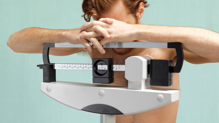Hombre frustrado sobre una báscula de peso corporal (Getty Images)