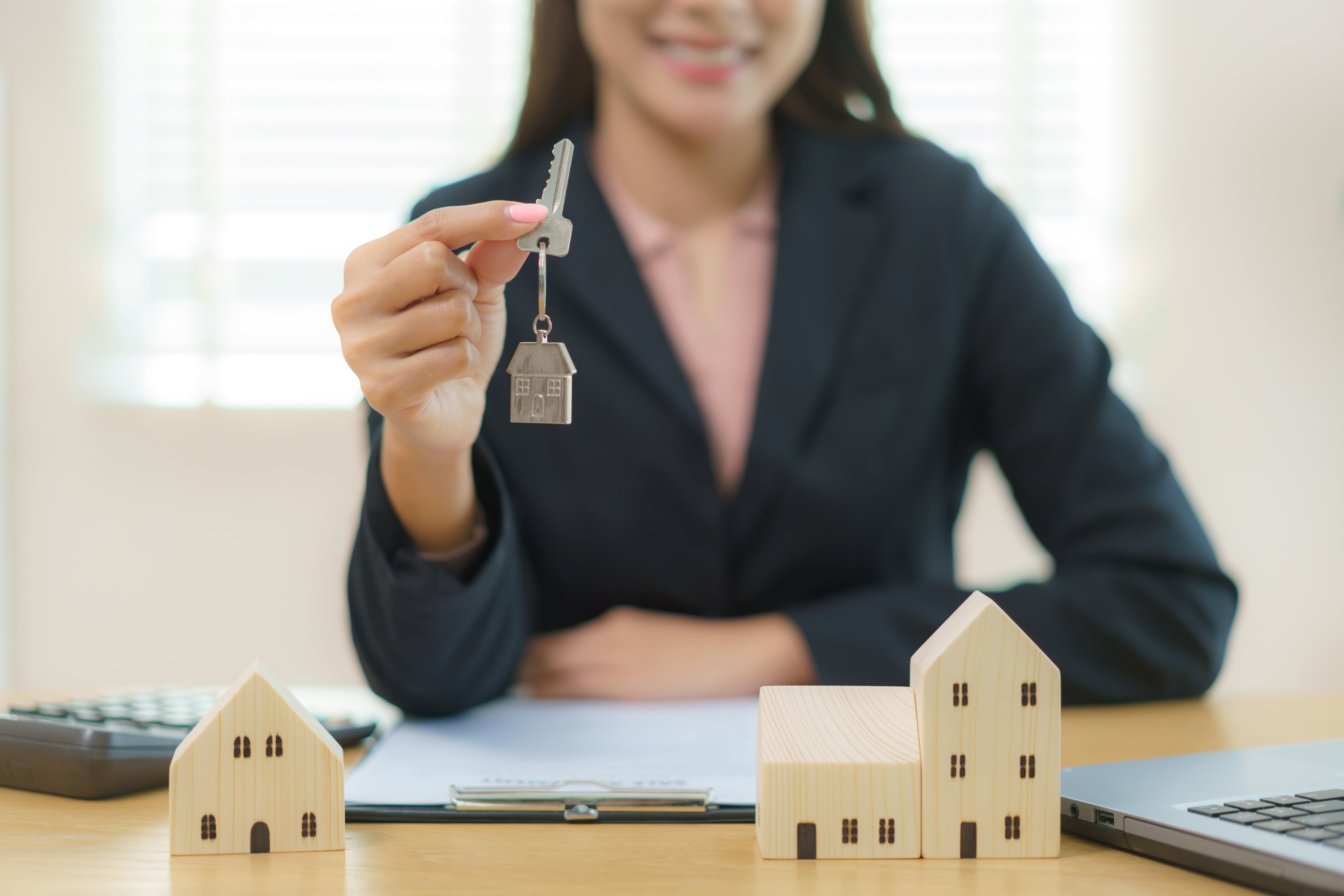 Real estate agent with house model and holding keys, customer signing contract to buy house, insurance or loan real estate.