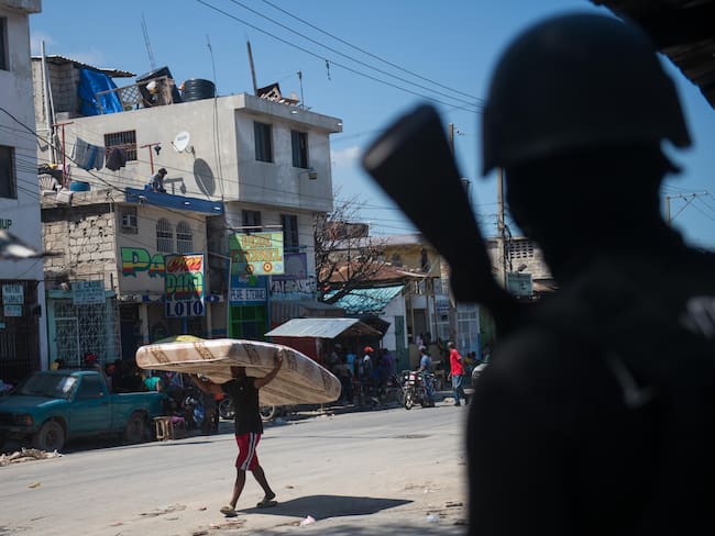 AME4424. PUERTO PRÍNCIPE (HAITÍ), 01/03/2024.- Un policía vigila, cuando la tensión volvió este viernes a Puerto Príncipe con tiroteos entre la Policía y las bandas armadas, después de que la capital haitiana amaneciera en aparente calma tras la violenta jornada de la víspera con al menos cinco muertos y una veintena de heridos, este viernes en Puerto Príncipe (Haití). Según el último balance del Sindicato de Policía de Haití, se elevan a cinco los efectivos que murieron el jueves y cuyos cuerpos aún no han podido ser recuperados. En un principio, se informó de que cuatro policías perdieron la vida al atacar las bandas armadas una comisaría en Bon Repos, en Canaan, en el norte de la capital. EFE/ Johnson Sabin