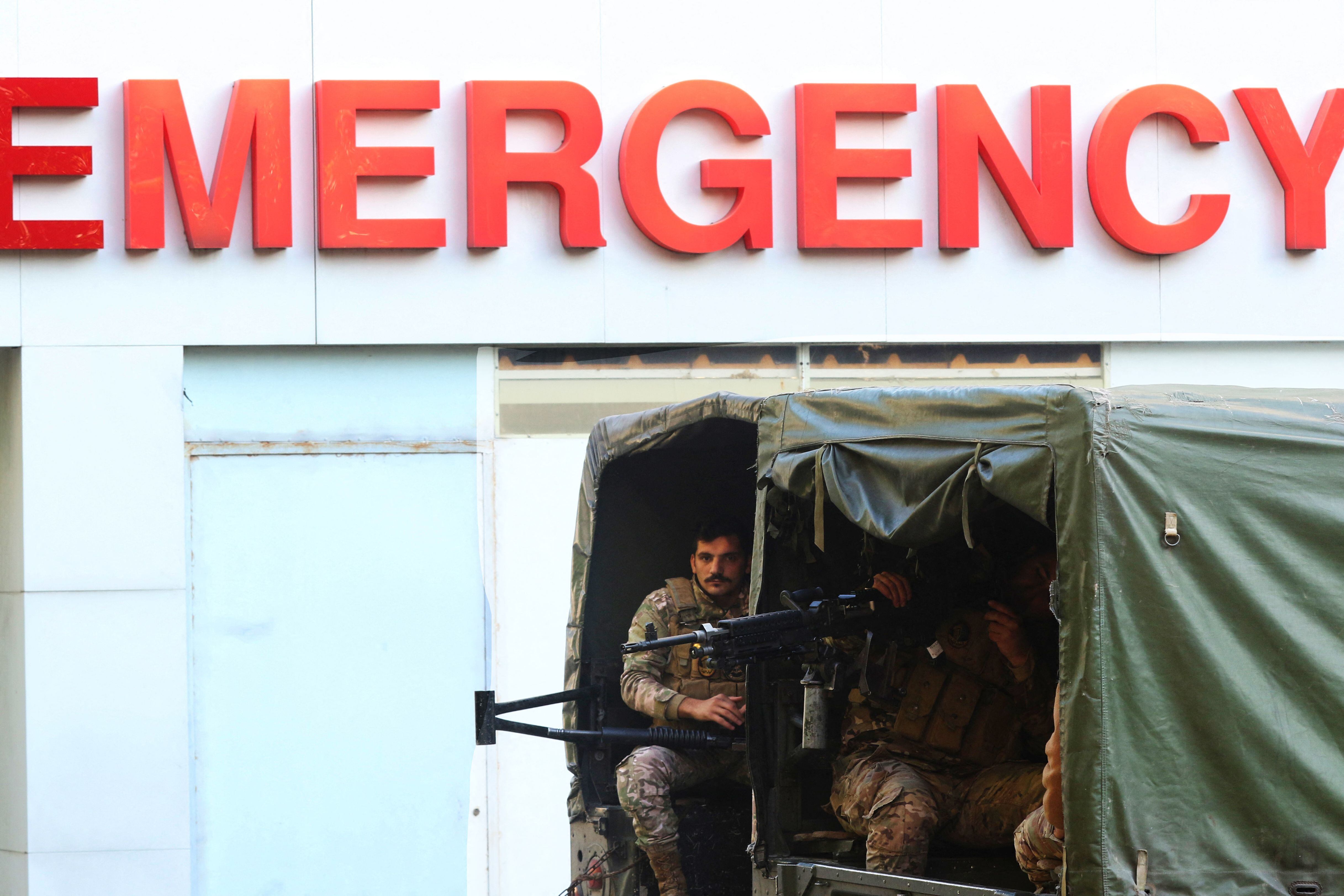 Lebanese security forces guard the emergency war of a hospital in the southern Lebanese city of Sidon during preparations to transfer the body of an Irish soldier from the United Nations Interim Force in Lebanon (UNIFIL) killed earlier this week in a shooting attack in the south, to Beirut international airport to be flown back home on December 18, 2022. - UNIFIL had urged Beirut to ensure a "speedy" investigation into the Irish soldier's shooting near the Israeli border after the peacekeeper's convoy came under fire late on December 14 near the southern Lebanese village of Al-Aqbiya, wounding three other members of the UNIFIL force. (Photo by Mahmoud ZAYYAT / AFP) (Photo by MAHMOUD ZAYYAT/AFP via Getty Images)