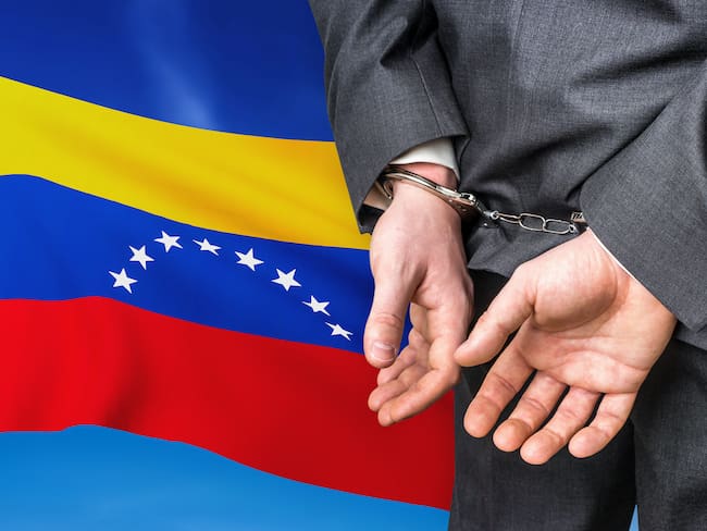 Prisons and corruption in Venezuela. Businessman with handcuffs on national flag background.