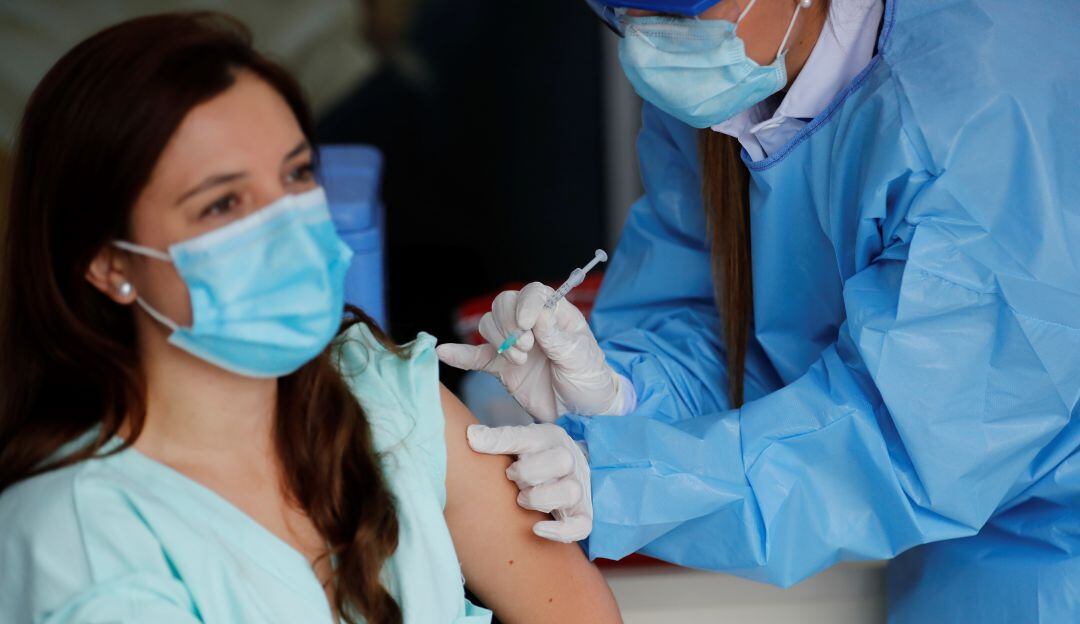 Una mujer del personal médico recibe una vacuna contra la Covid-19 hoy, en la clínica Colombia, en Bogotá