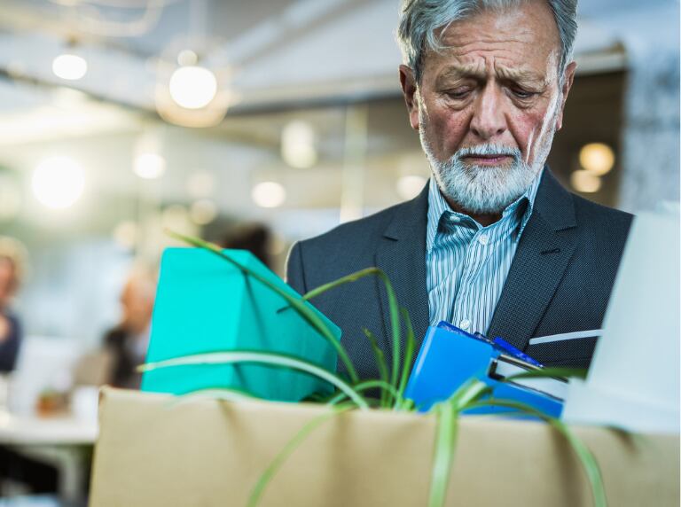 Hombre mayor saliendo de su oficina después de ser despedido (Getty Images)