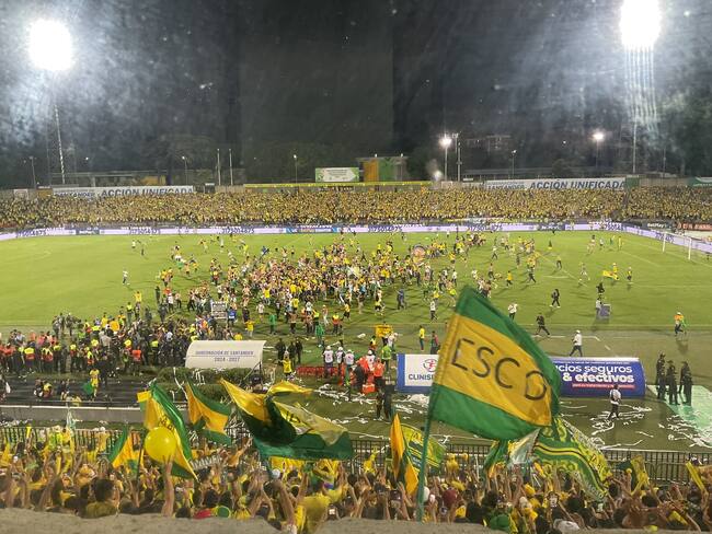 Hinchas del Bucaramanga invadiendo el terreno de juego del estadio Alfonso López / Twitter: @JFCadavid.