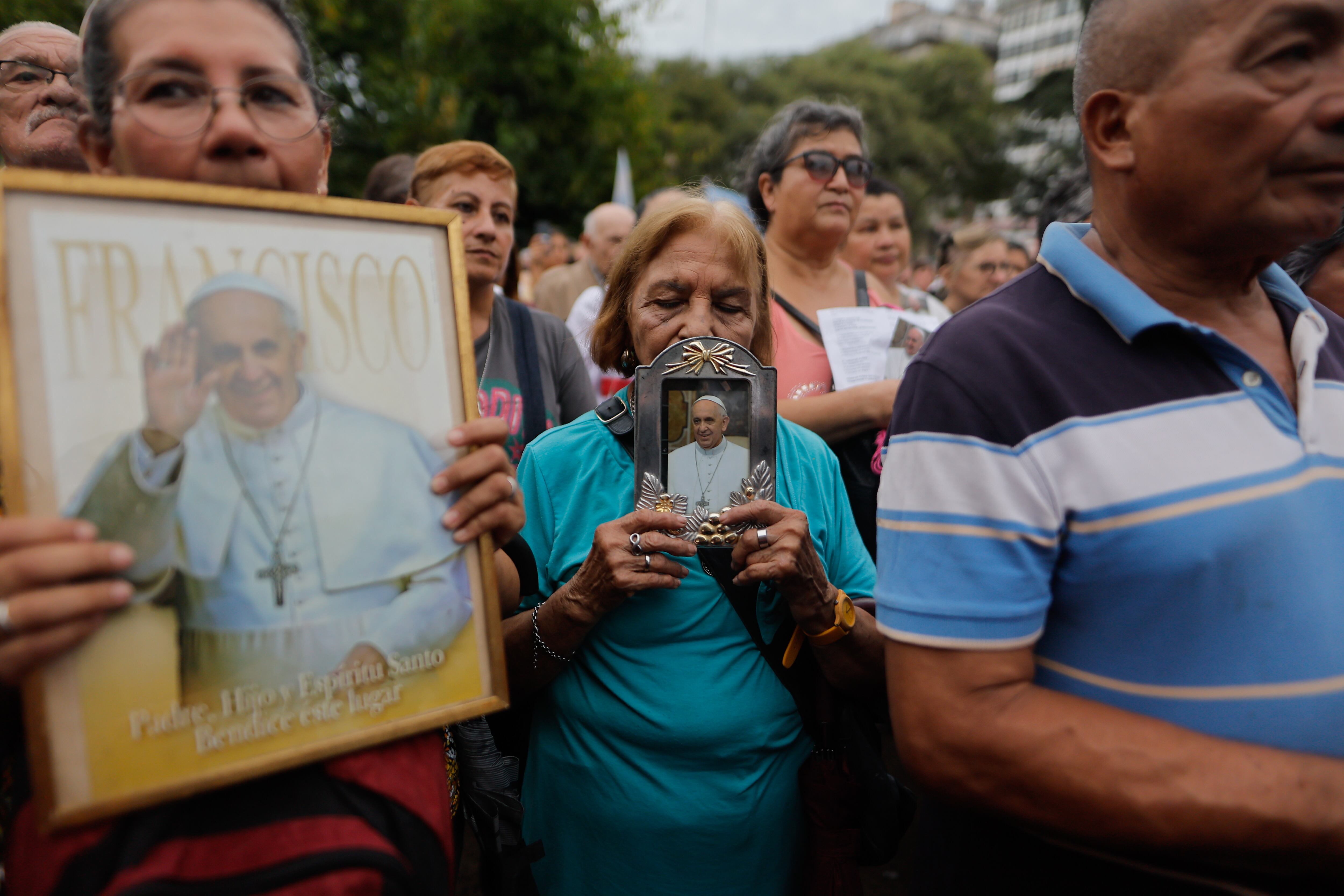 AME3189. BUENOS AIRES (ARGENTINA), 24/02/2025.- Personas sostienen fotografías del Papa Francisco durante una misa este lunes, en la Plaza Constitución en Buenos Aires (Argentina). EFE/Juan Ignacio Roncoroni