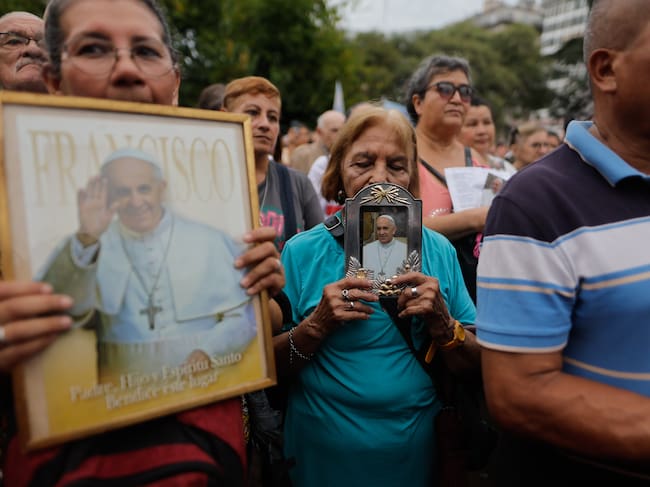 AME3189. BUENOS AIRES (ARGENTINA), 24/02/2025.- Personas sostienen fotografías del Papa Francisco durante una misa este lunes, en la Plaza Constitución en Buenos Aires (Argentina). EFE/Juan Ignacio Roncoroni