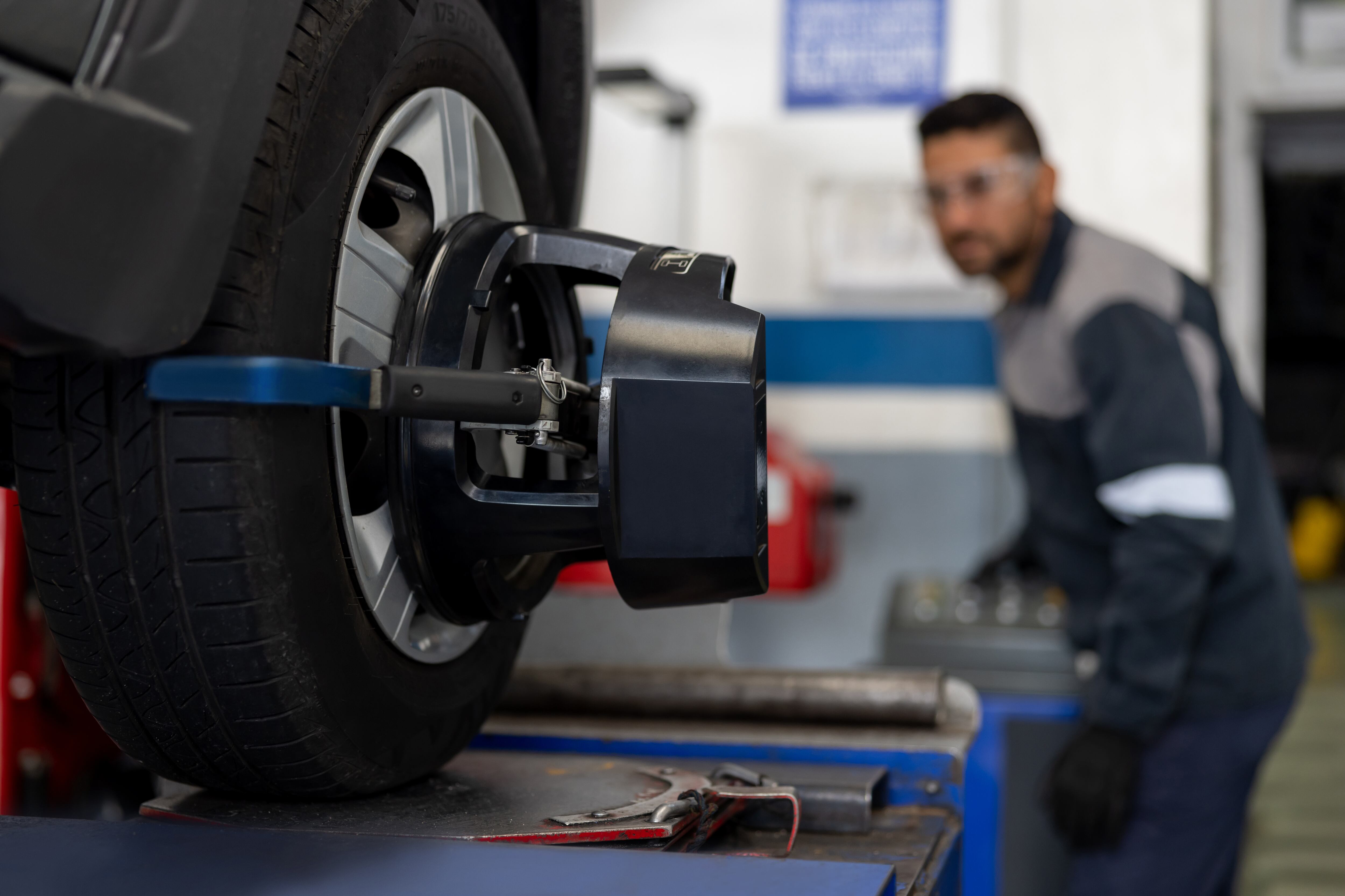 Mecánico alineando un neumático de automóvil en un taller de reparación de automóviles - Fotografía de stock