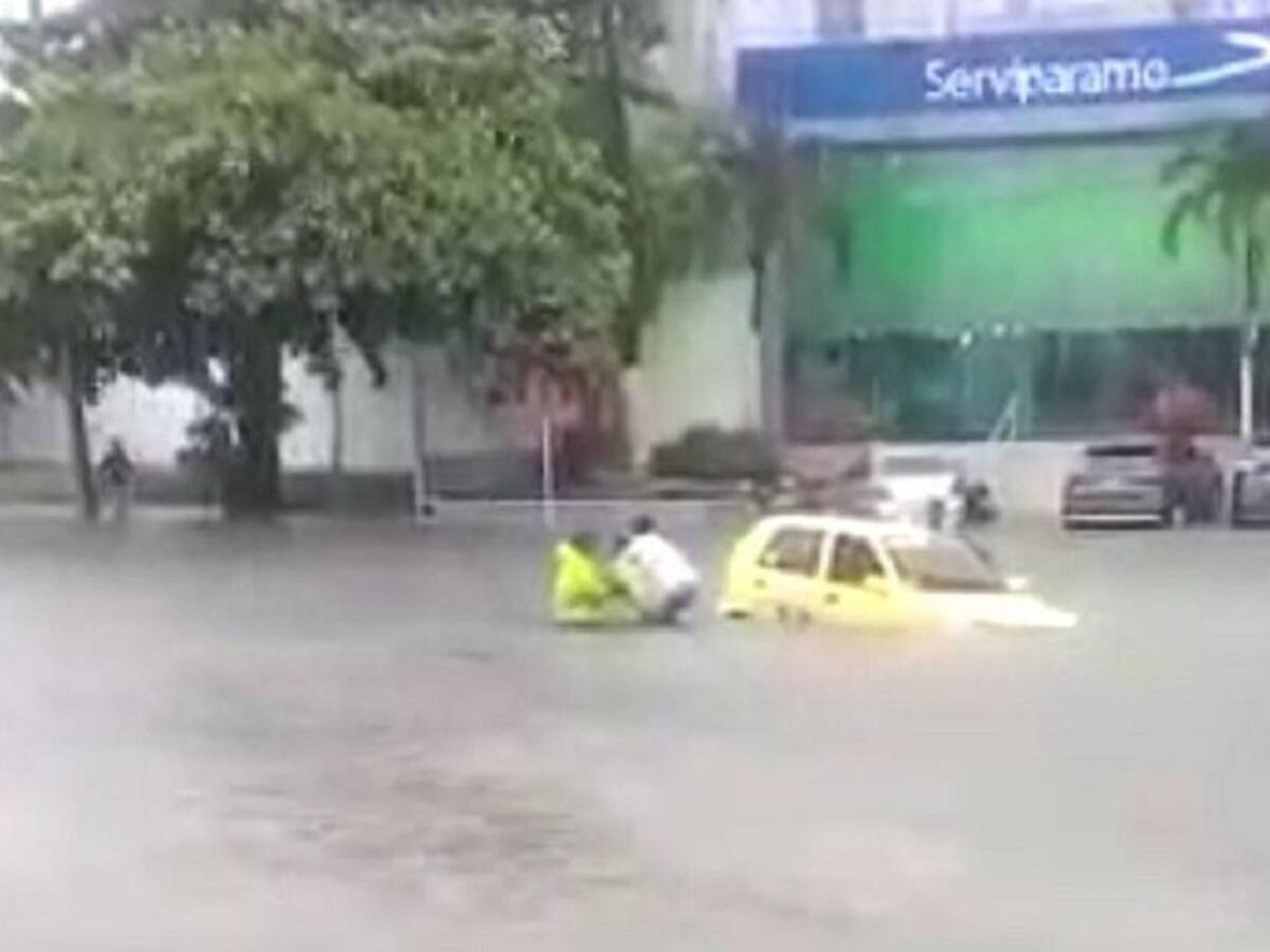 Policías rescatan a ocupantes de taxi en medio de un arroyo en Barranquilla