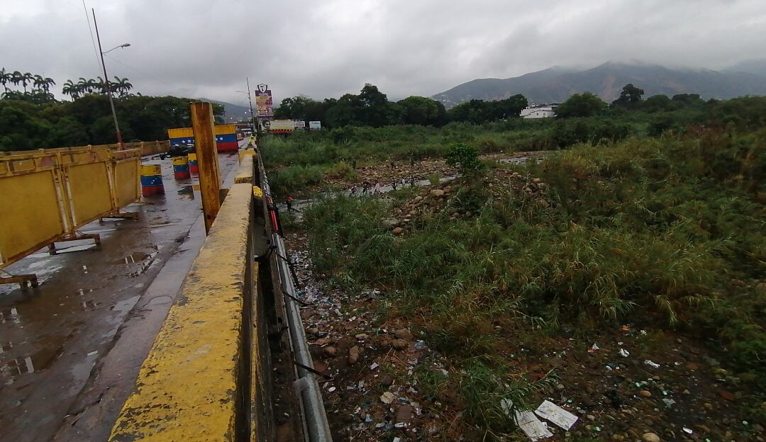 Migrantes pasando por debajo del puente binacional
