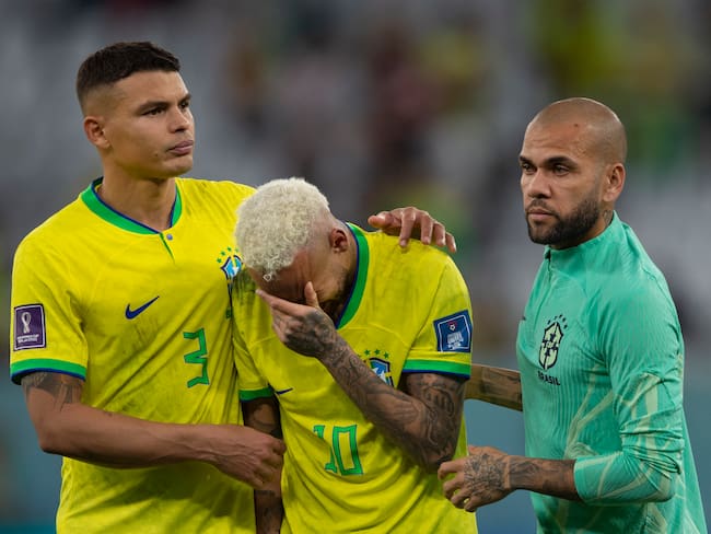 AL RAYYAN, QATAR - DECEMBER 09: Neymar of Brazil is consoled by team mates Thiago Silva and Dani Alves during the FIFA World Cup Qatar 2022 quarter final match between Croatia and Brazil at Education City Stadium on December 9, 2022 in Al Rayyan, Qatar. (Photo by Visionhaus/Getty Images)