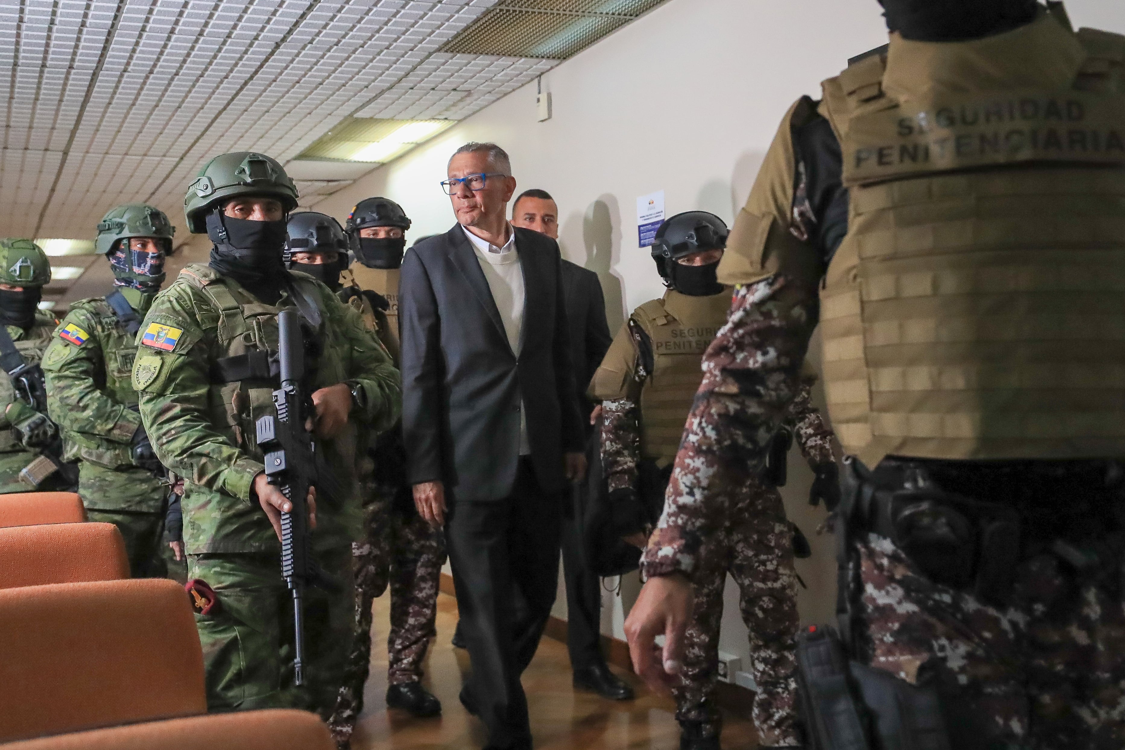 AME9864. QUITO (ECUADOR), 30/06/2025.- El exvicepresidente de Ecuador Jorge Glas (c), es custodiado por integrantes de la policía a su llegada al juicio este lunes, en la Corte Nacional de Justicia, en Quito (Ecuador). Un tribunal de la Corte Nacional de Justicia de Ecuador decidió por unanimidad condenar a 13 años de cárcel al exvicepresidente correísta Jorge Glas por peculado (malversación de fondos públicos) durante el proceso de reconstrucción de las zonas afectadas por el terremoto de 2016. EFE/José Jácome