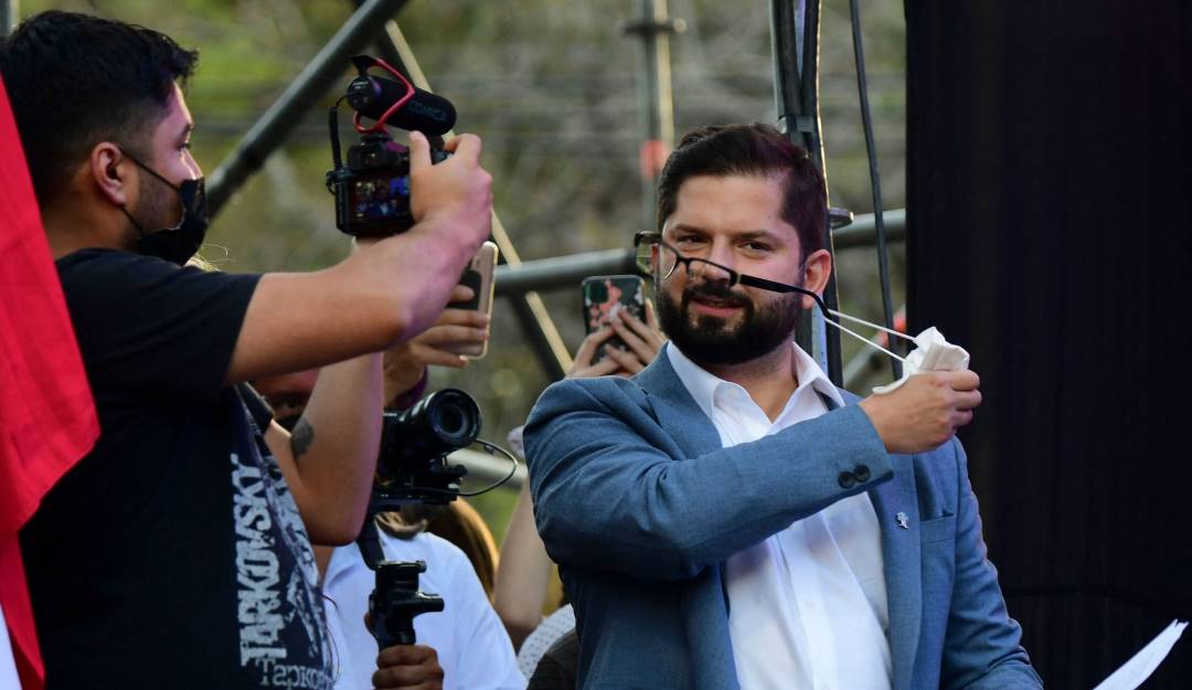 El presidente chileno, Gabriel Boric, se retira el tapabocas.                 Foto: Getty 