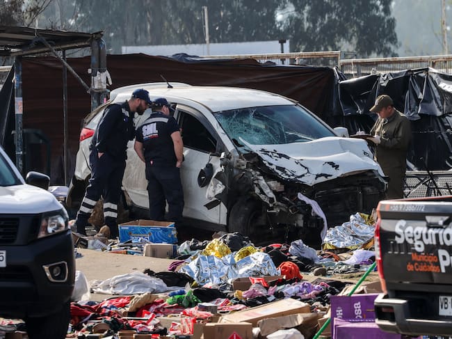 Members of the Carabineros work next to a vehicle that struck several people at a street market in Vina del Mar, Chile, on July 12, 2026. At least six people were killed and seven others were injured on July 12 after being struck by a vehicle at a street market in Vina del Mar, Chilean police said. (Photo by Cristobal BASAURE / AFP)