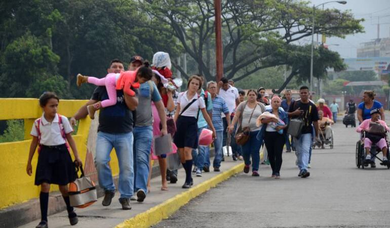 Niños y adultos cruzando frontera entre Colombia y Venezuela.