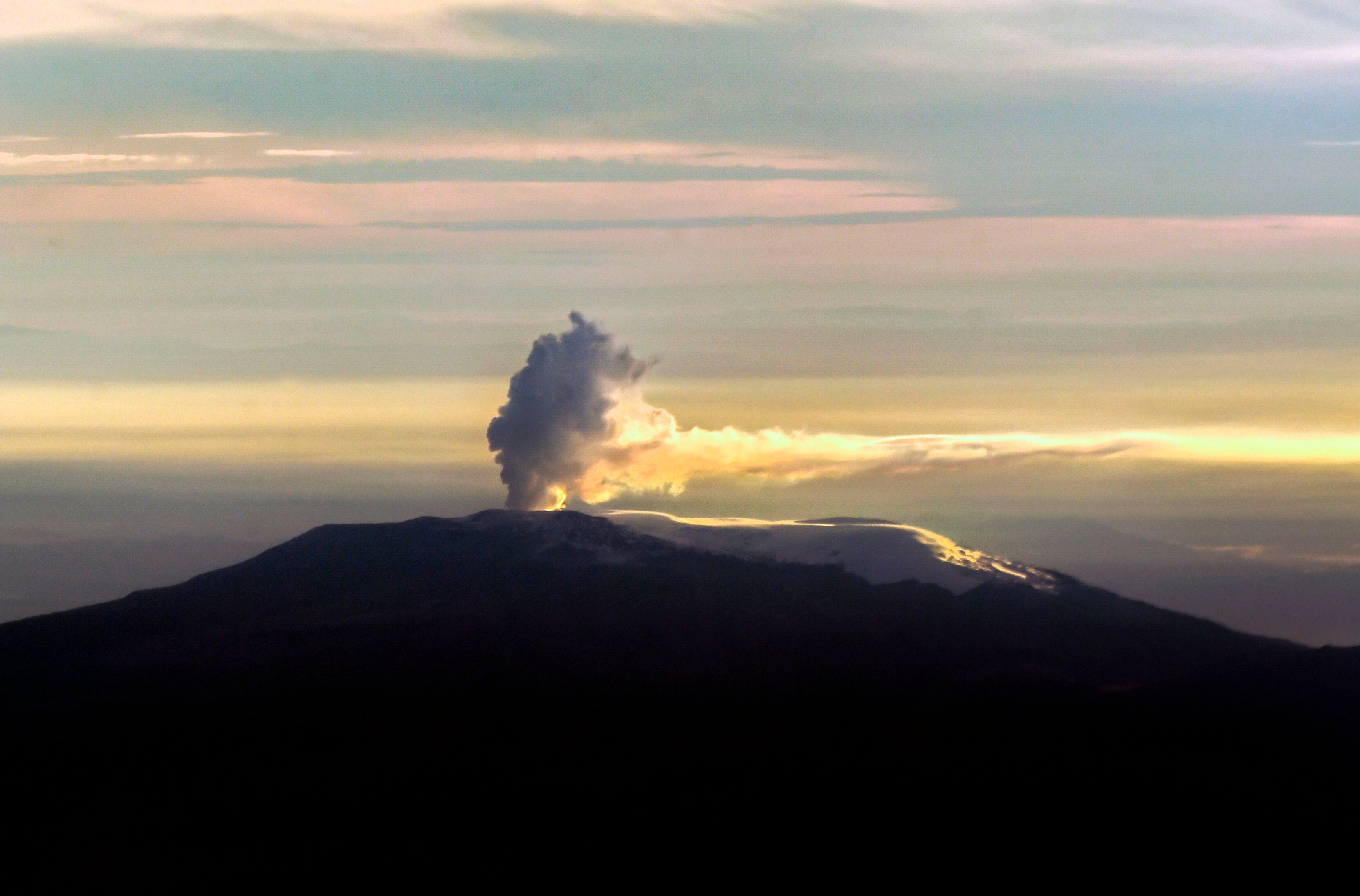 Vista aérea del volcán Nevado del Ruiz que muestra una columna de humo fotografiada al amanecer desde la ventana de un avión el 29 de noviembre de 2018 en Colombia. Foto: LUIS ROBAYO/AFP a través de Getty Images.