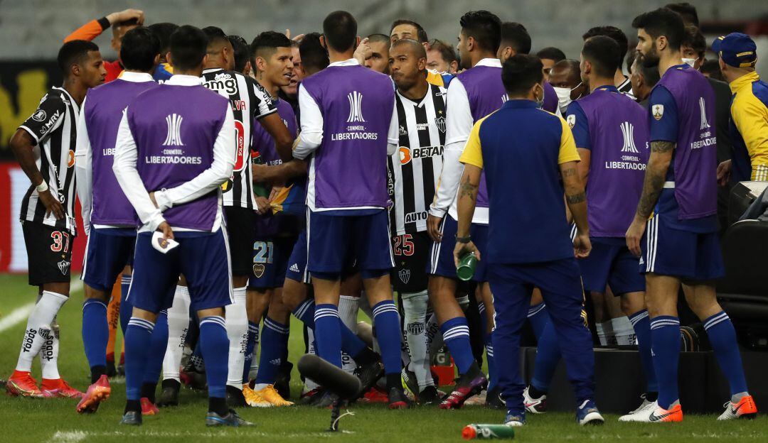 Los jugadores de Boca Juniors y los de Atlético Mineiro se enfrentan mientras el árbitro revisa el VAR.