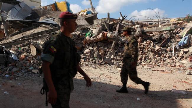 Soldados ecuatorianos caminan cerca de la estructura de un hotel desplomado tras el sismo de 7,8 grados que sacudió al país el pasado sábado 16 de abril. Foto: Agencia EFE