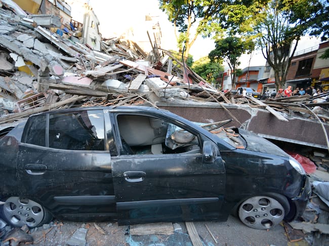 Auto destruido debido a los escombros de un edificio derrumbado cerca de la Plaza Bolívar después de un terremoto de magnitud 7,4 en Pereira, Colombia. (Foto de Gabriel Aponte/Getty Images)