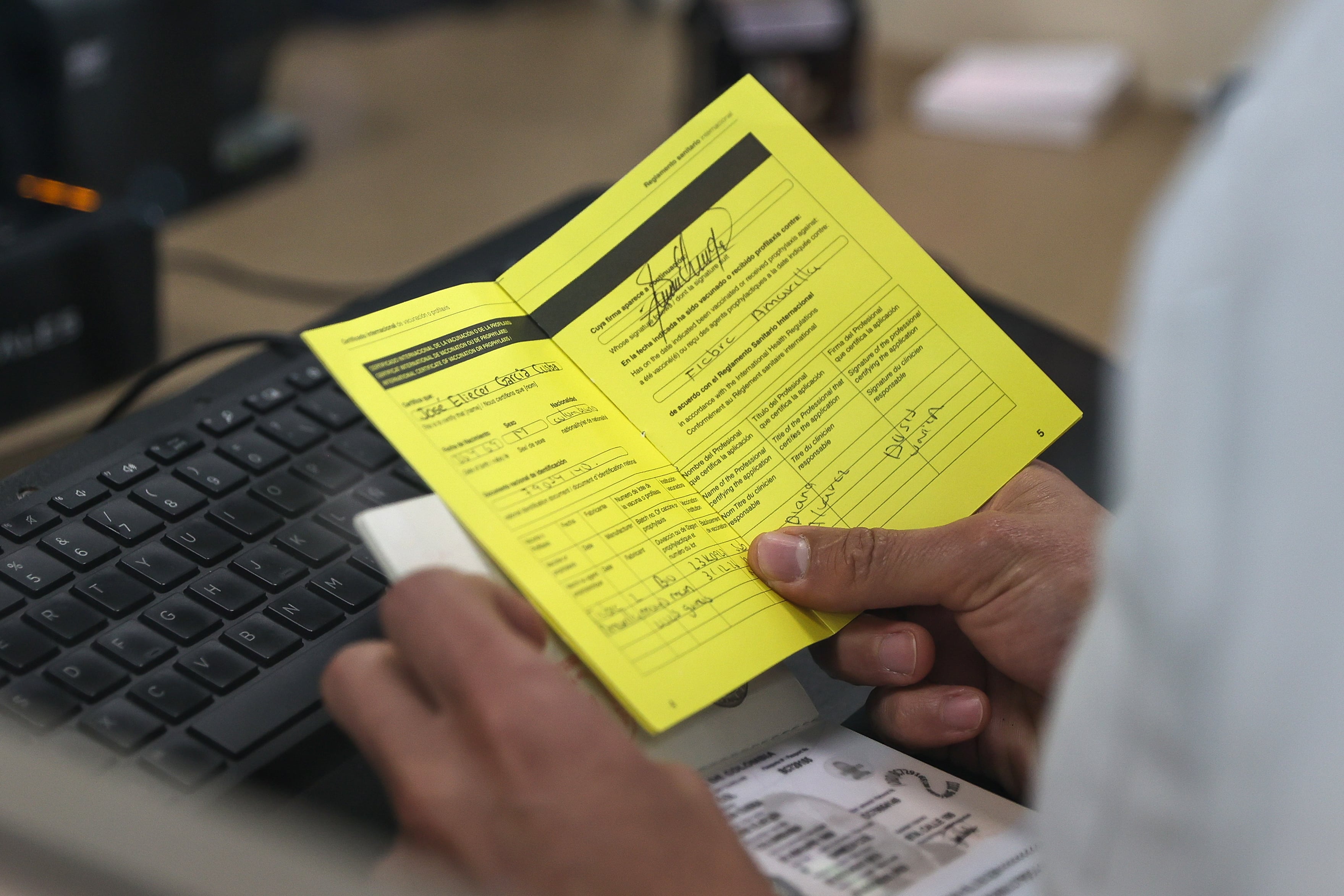 QUI01. QUITO (ECUADOR) 12/05/2025.- Un integrante del servicio de migración, revisa el certificado internacional de vacunación contra la fiebre amarilla de un turista, este lunes en el Aeropuerto Internacional Mariscal Sucre de Quito (Ecuador). El Gobierno de Ecuador comenzó exigir desde este lunes certificado de vacunación contra la fiebre amarilla a todos los viajeros que lleguen al país procedentes de Bolivia, Brasil, Colombia y Perú que hayan permanecido al menos diez días en esos países, una medida que aplica también a los propios ecuatorianos que entren a territorio ecuatoriano. EFE/José Jácome