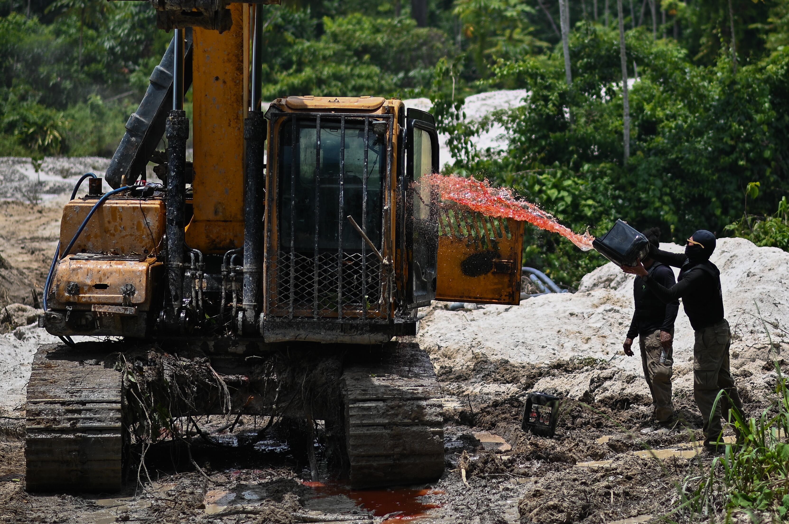 AME8476. ITAITUBA (BRASIL), 17/05/2025.- Fotografía de archivo del 14 de febrero de 2023 de un agente ambiental federal lanzando combustible a una retro excavadora utilizada para minería ilegal, durante un operativo del Instituto Chico Mendes (ICMBio), en la Floresta Ambiental de Altamira, estado de Pará (Brasil). La minería ilegal se ha convertido en una de las principales amenazas para la seguridad, el medioambiente y la gobernabilidad en Sudamérica. Con Perú y Ecuador al borde del colapso institucional en ciertas regiones, el fenómeno también golpea con fuerza a Brasil, Colombia y Guatemala. Solo Chile parece haberse blindado ante esta plaga. EFE/ Andre Borges