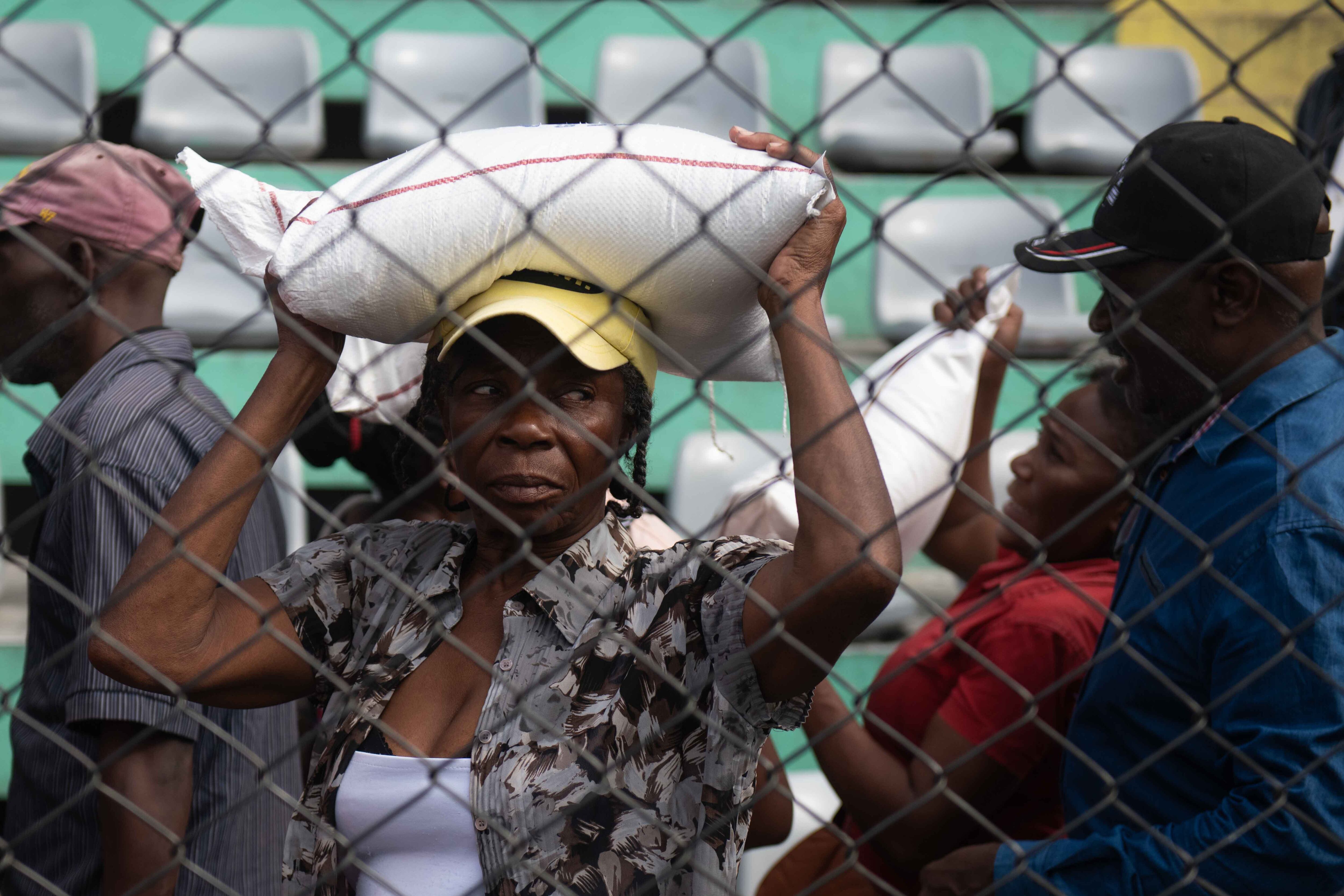 AME8069. PUERTO PRÍNCIPE (HAITÍ), 31/12/2024.- Una mujer recibe alimentos durante una jornada solidaria este martes, en Puerto Príncipe (Haití). El Gobierno haitiano organizó una jornada de solidaridad con los desplazados que viven en campamentos en condiciones infrahumanas en Pétion-ville, en medio de la grave crisis generalizada que atraviesa la empobrecida nación caribeña, agravada por la violencia de las sangrientas bandas armadas. EFE/ Johnson Sabin