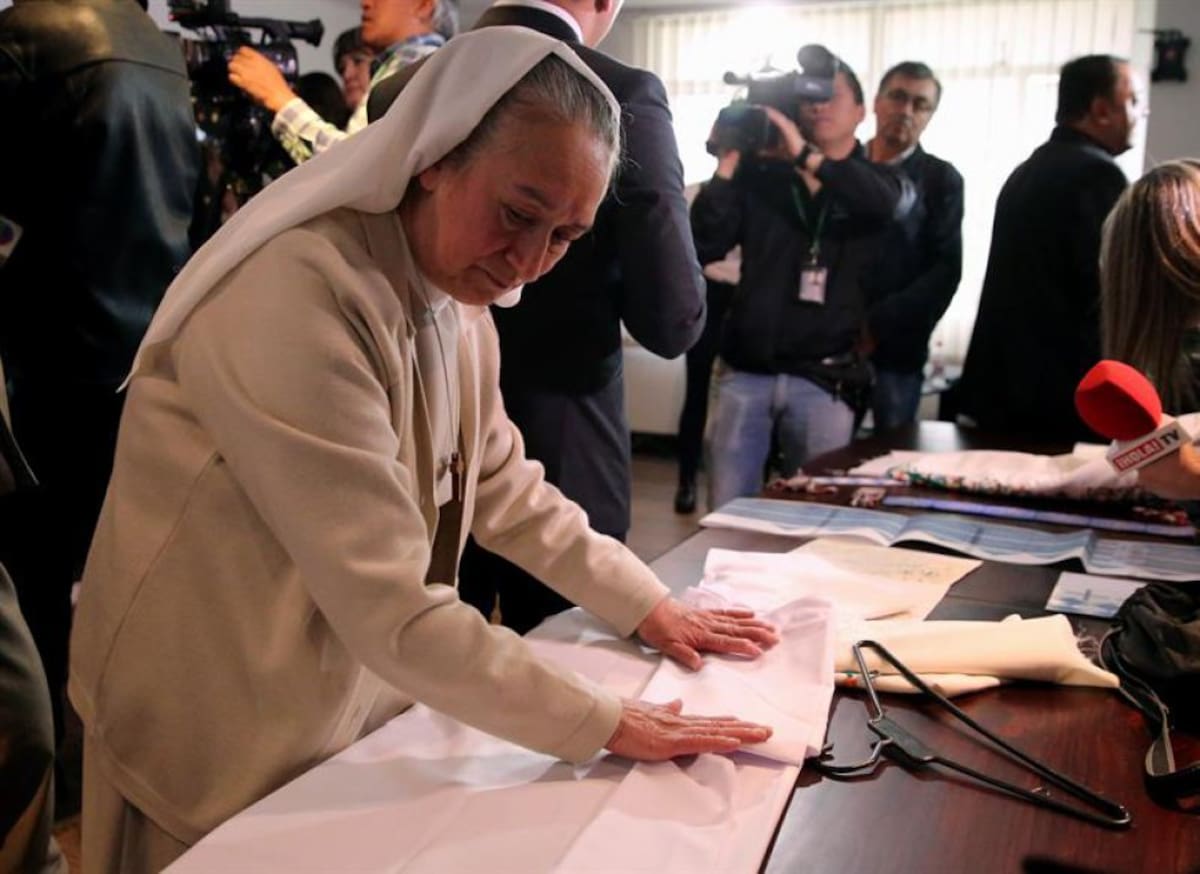 Una monja dobla las vestiduras litúrgicas que el papa Francisco utilizará durante su visita a Colombia 