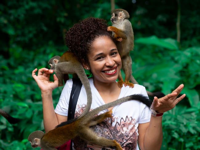 Mujer haciendo turismo en la región del Amazonas con los monos de la zona (Foto vía Getty Images)
