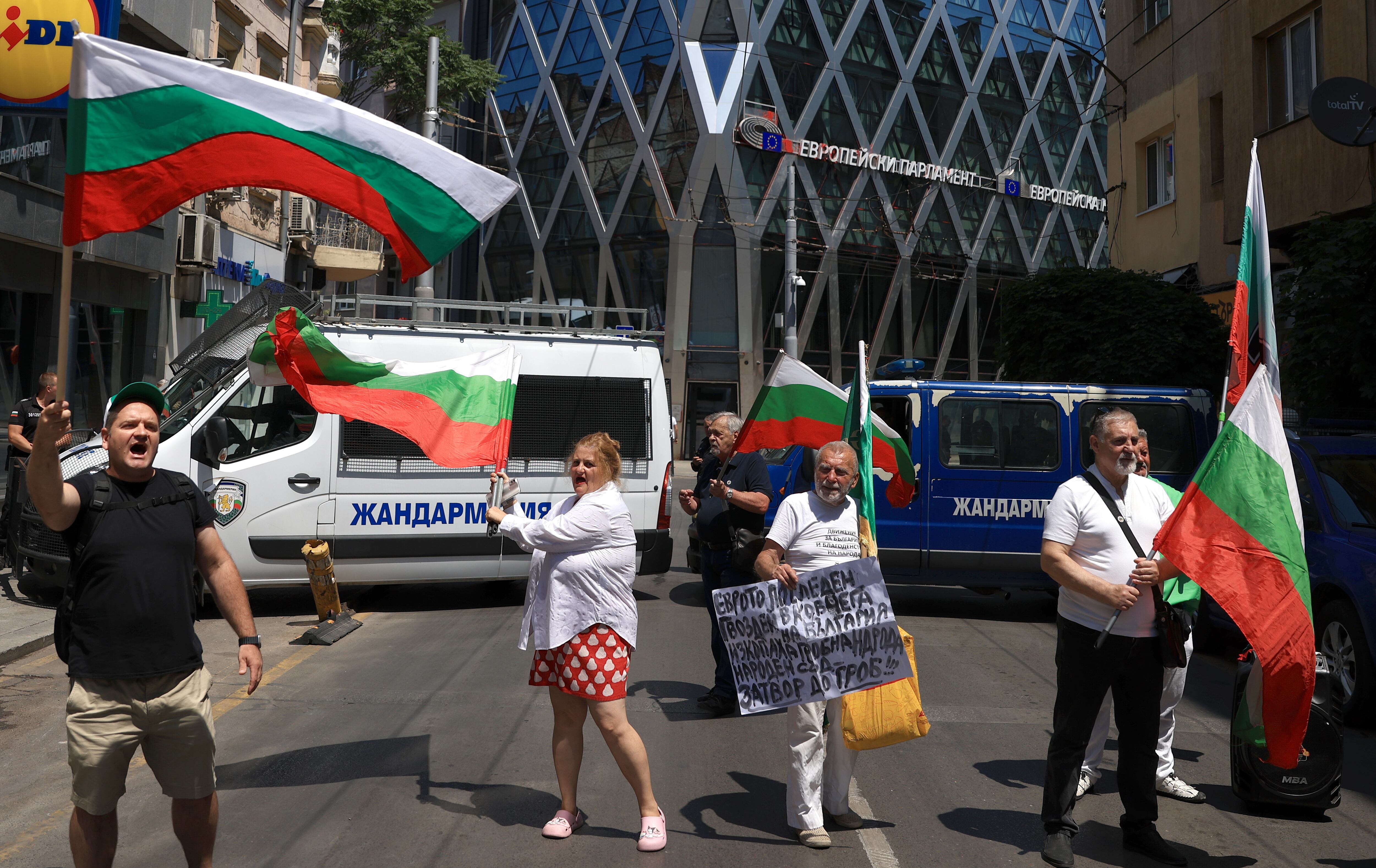 Sofia (Bulgaria), 08/07/2025.- People wave national flags during a protest against the adoption of the Euro, in front of the European Parliament building in Sofia, Bulgaria, 08 July 2025. The European Parliament and, following a decision by the Economic and Financial Affairs Council in Brussels, will make the final decisions that will determine whether Bulgaria will join the Eurozone. (Protestas, Bruselas) EFE/EPA/VASSIL DONEV