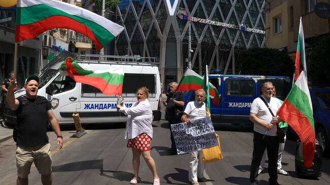 Sofia (Bulgaria), 08/07/2025.- People wave national flags during a protest against the adoption of the Euro, in front of the European Parliament building in Sofia, Bulgaria, 08 July 2025. The European Parliament and, following a decision by the Economic and Financial Affairs Council in Brussels, will make the final decisions that will determine whether Bulgaria will join the Eurozone. (Protestas, Bruselas) EFE/EPA/VASSIL DONEV